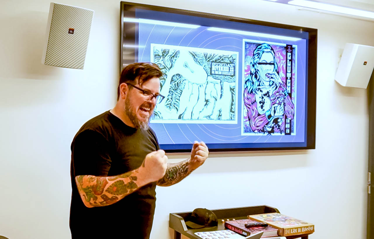 speaker talking in front of a monitor showing his work